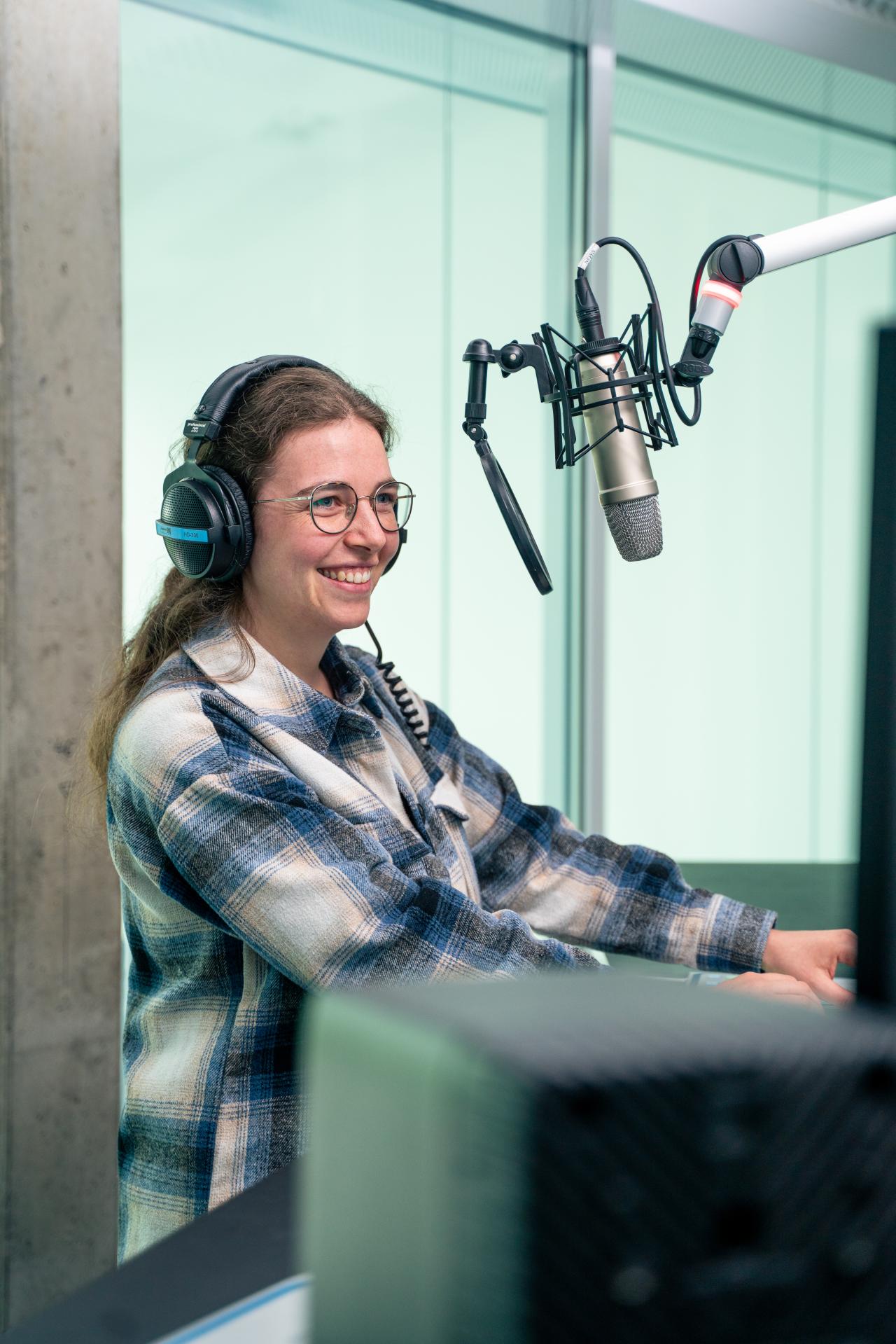Studentin moderiert eine Live-Radio Sendung im Sendestudio